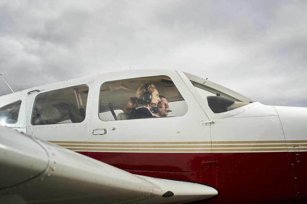 Plane in flight. Female flight instructor giving flight lessons to a student.